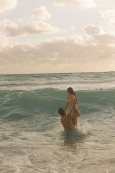 two people in the ocean playing with each other