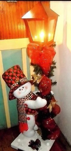 a snowman statue sitting next to a lamp