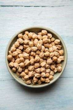 a bowl filled with peanuts on top of a wooden table