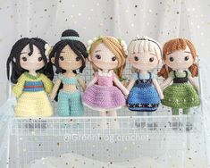 four crocheted dolls sitting on top of a shelf