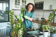 a woman is standing in the kitchen with potted plants