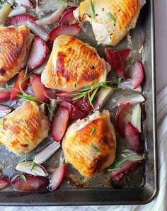 chicken and radishes on a baking sheet ready to be cooked in the oven