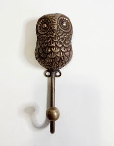 an owl shaped door handle on a white wall