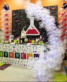 an assortment of balloons and decorations for a science themed birthday party with the name is able la