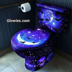 a toilet that has been decorated with bats and stars in the night sky on it