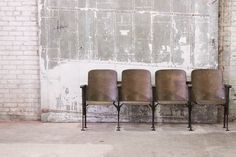 four chairs are lined up against a wall