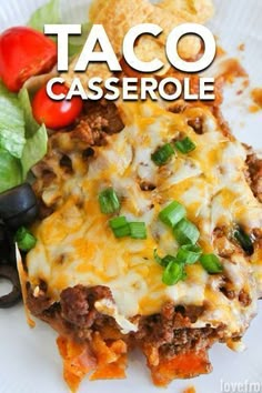 taco casserole on a white plate with lettuce and tomatoes