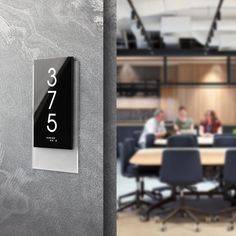 an office with people sitting around a table and numbers on the wall