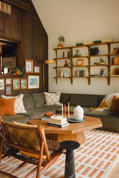 a living room filled with lots of furniture and bookshelves on top of wooden shelves