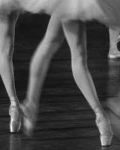 black and white photo of two ballerinas in tutu skirts, one wearing ballet shoes