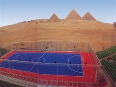 an aerial view of a basketball court in front of the pyramids at giza