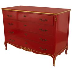 a red dresser with gold trimmings on the top and bottom drawers, against a white background