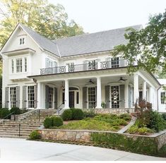 a large white house with lots of windows and steps leading up to the front door