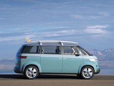 a small blue van with surfboards on the roof