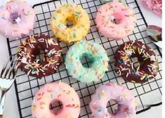 there are many doughnuts on the cooling rack and one has sprinkles