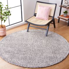 a chair sitting on top of a hard wood floor next to a potted plant