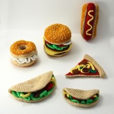 crocheted food items are arranged in the shape of hamburgers and pizza slices