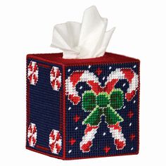 a tissue box decorated with candy canes and bow on it's side,