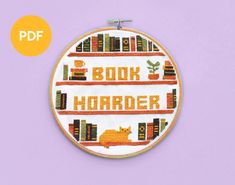 a cross stitch pattern with the words book hoarder and a cat sitting on bookshelves