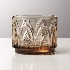 a glass candle holder sitting on top of a table