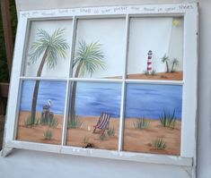 an old window with beach scenes painted on the glass and palm trees in the background