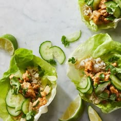 three lettuce cups with cucumbers and other toppings on them sitting on a table