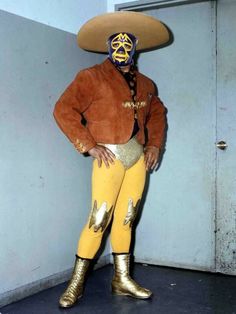 a man wearing a sombrero and gold pants stands with his hands on his hips