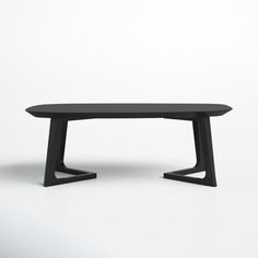 an oval table with black legs on a white background in front of a plain wall