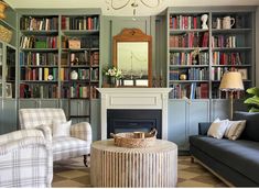 a living room filled with furniture and bookshelves covered in lots of bookcases