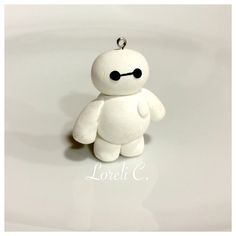 a white teddy bear with black eyes sitting on top of a table next to a keychain