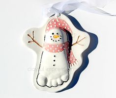 a snowman ornament hanging from a white ribbon