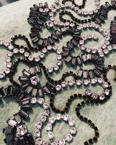 an assortment of black and clear jeweled necklaces on a green cloth with beads