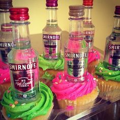 cupcakes with pink, green and blue frosting in front of bottles of smirnoff vodka