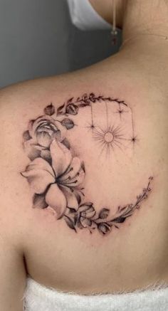 a woman's shoulder with a flower tattoo on it