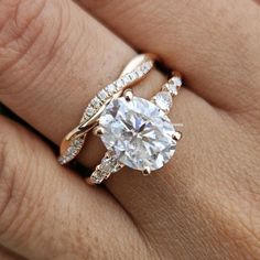 a woman's hand with a diamond ring on top of her finger and the engagement band