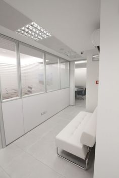 a white couch sitting in the middle of a room next to a wall with sliding glass doors