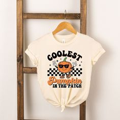 Looking for a cute tee for your kids? We have the perfect Coolest Pumpkin In The Patch graphic tee addition to their closet! Cool Graphic Print Tops For Fall, Cool Crew Neck T-shirt With Funny Print, Fun Screen Print T-shirt For Fall, Cute Fall T-shirt With Screen Print, Cute Slogan T-shirt For Fall, Fun Fall Screen Print T-shirt, Fun Fall T-shirt With Screen Print, Halloween Graphic Tee With Front And Back Print, Cute Fall T-shirt With Slogan