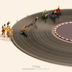 small toy figurines standing on top of a record player's track,