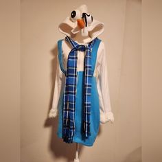 a blue and white dress hanging on a wall next to a mannequin's head