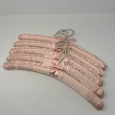 several pieces of pink fabric tied together on a white surface with no one around them