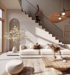 a living room filled with furniture and a stair case in front of a large window