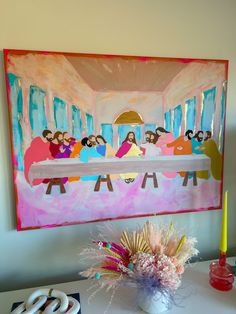 the last supper painting is displayed in front of a vase with flowers and candles on it