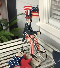 a statue of a man riding a bike with an american flag on it's back