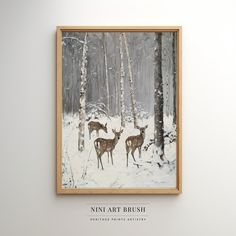 two deer standing in the snow near some trees