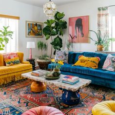 a living room filled with lots of colorful furniture and plants on top of the couches