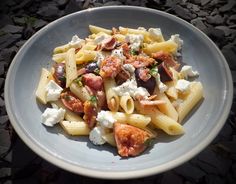 a white plate topped with pasta and meat covered in fettuccine, cheese and tomatoes