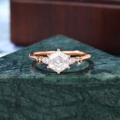 a diamond ring sitting on top of a green marble slab