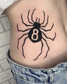 a black spider tattoo on the side of a woman's lower back ribcage