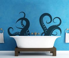 an octopus wall decal in a bathroom next to a white bathtub and blue walls