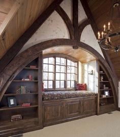 a room with an arched window, bookshelf and built in bookcases